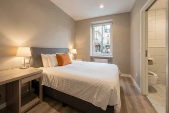 Chambre standard de l'hôtel ibis Libourne avec lit double, bureau de travail et salle de bain, décoration épurée et fonctionnelle