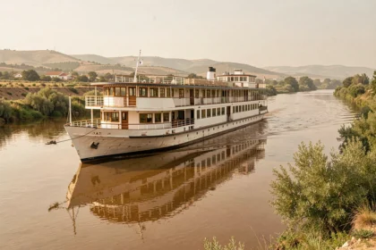 Bateau de croisière fluviale naviguant sur le Guadalquivir en Andalousie avec des berges verdoyantes